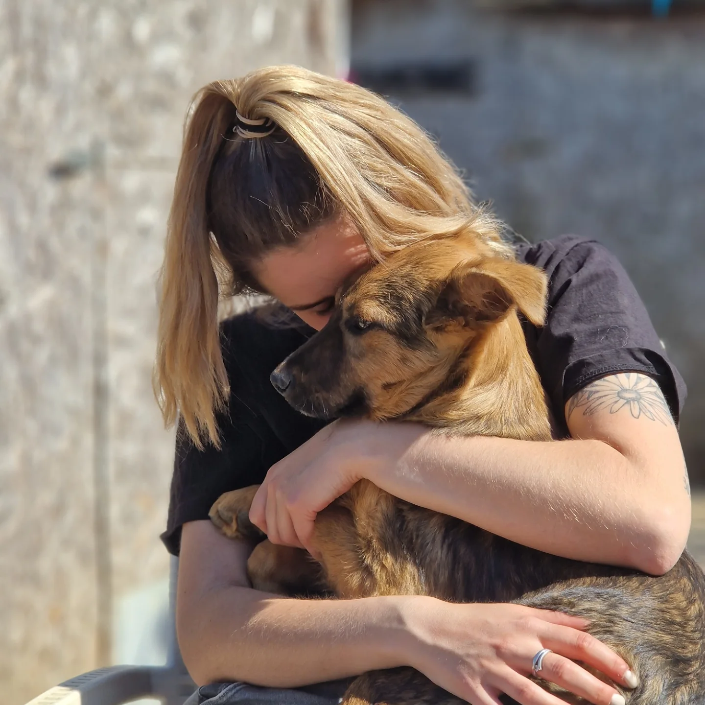 Samantha knuffelt een asielhond in Roemenië